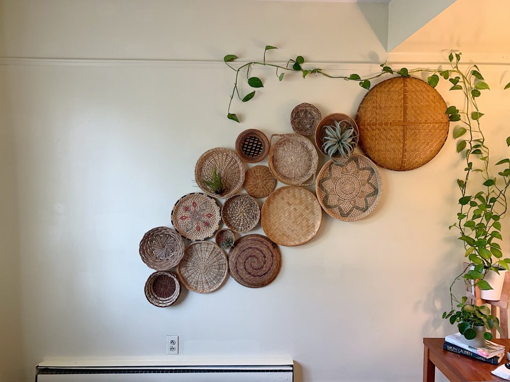 wall with thrifted boho baskets and climbing pothos houseplant