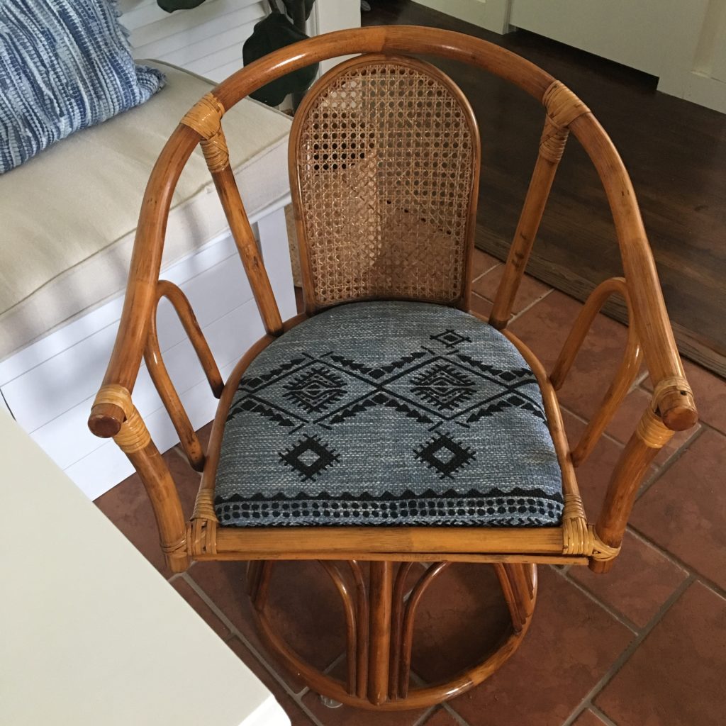 vintage boho style cane back swivel chair with upholstered seat from five below rug, positioned near dining banquette on terracotta tile floor