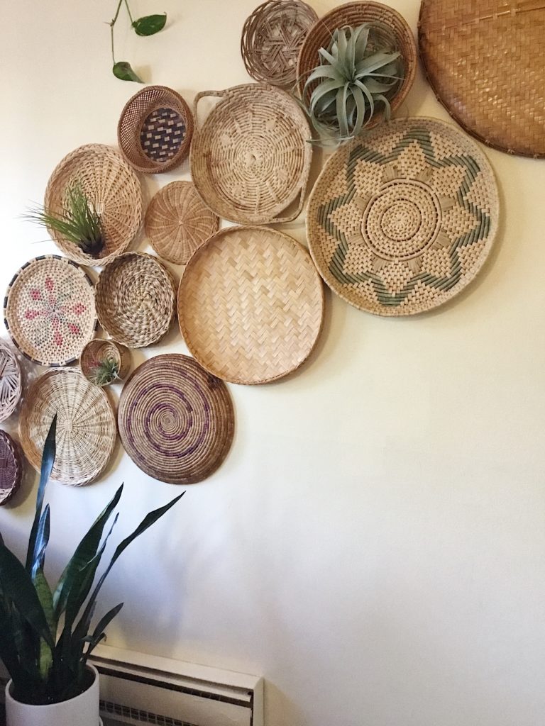 Large grouping of boho baskets displayed on wall with air plants