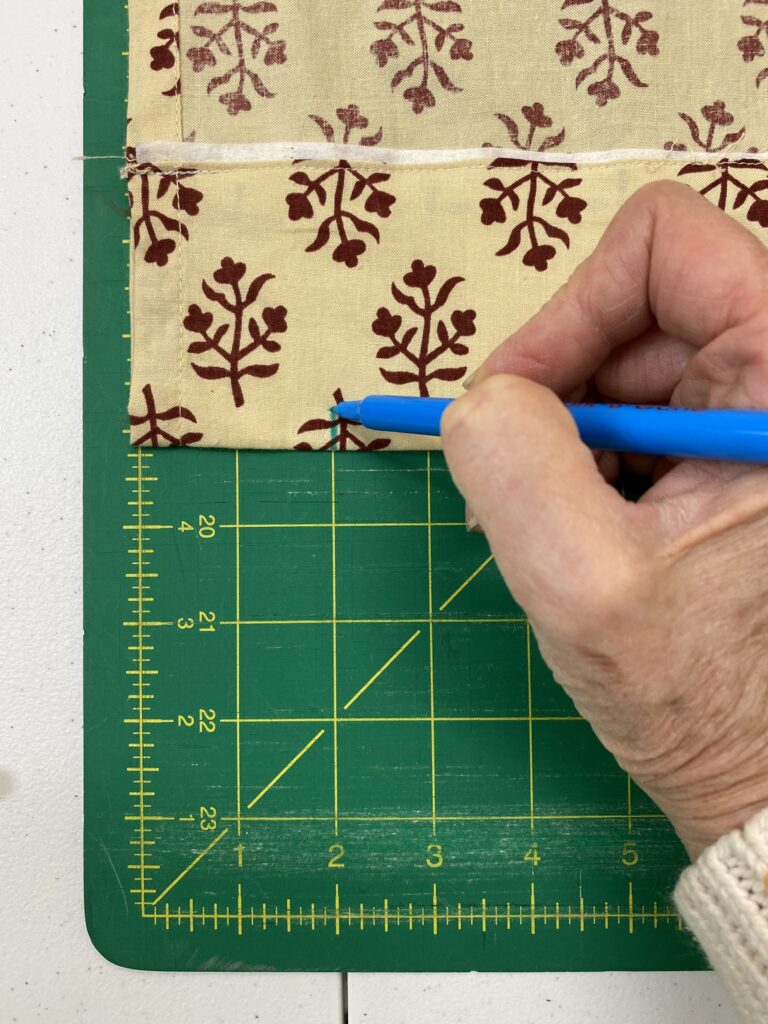 hand using fabric marker on curtains