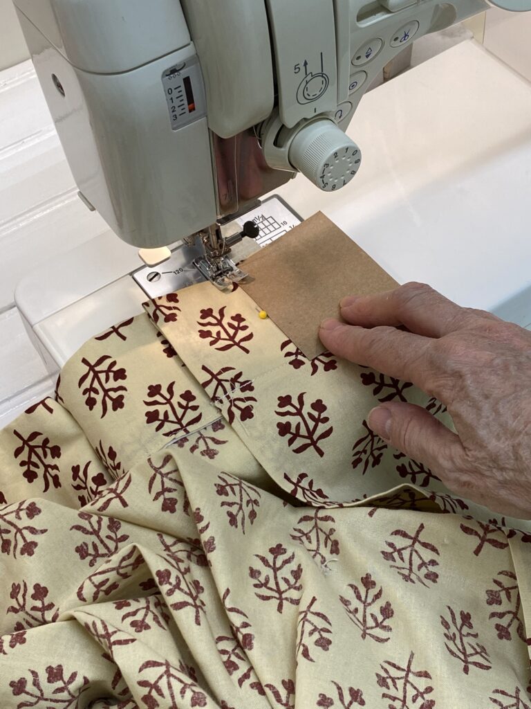 ditsy print cream curtain being sewn on sewing machine