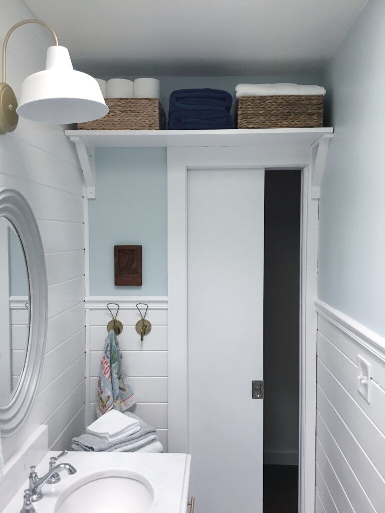 above the door shelf with towels and baskets