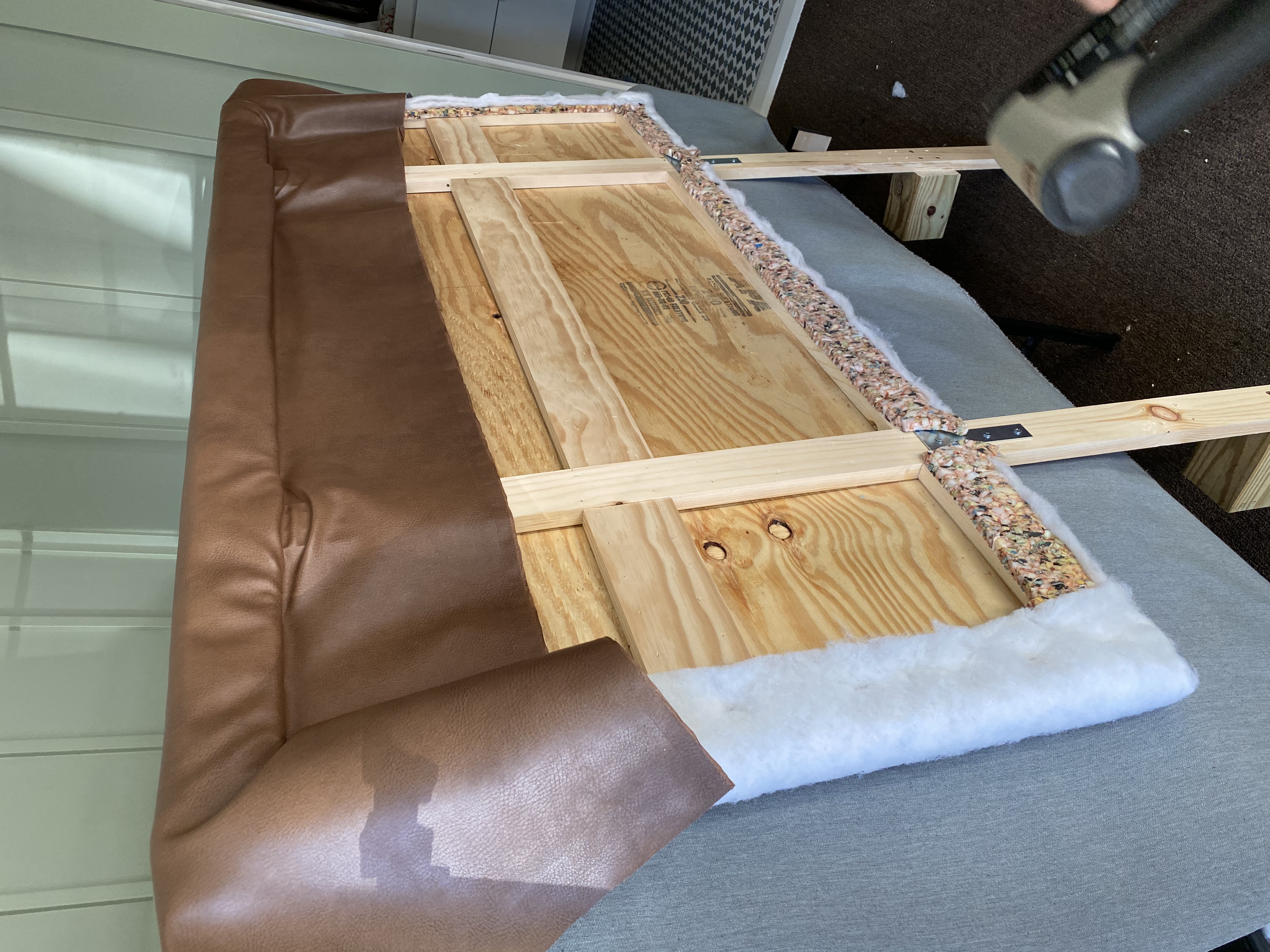 Leather stapled to plywood headboard 