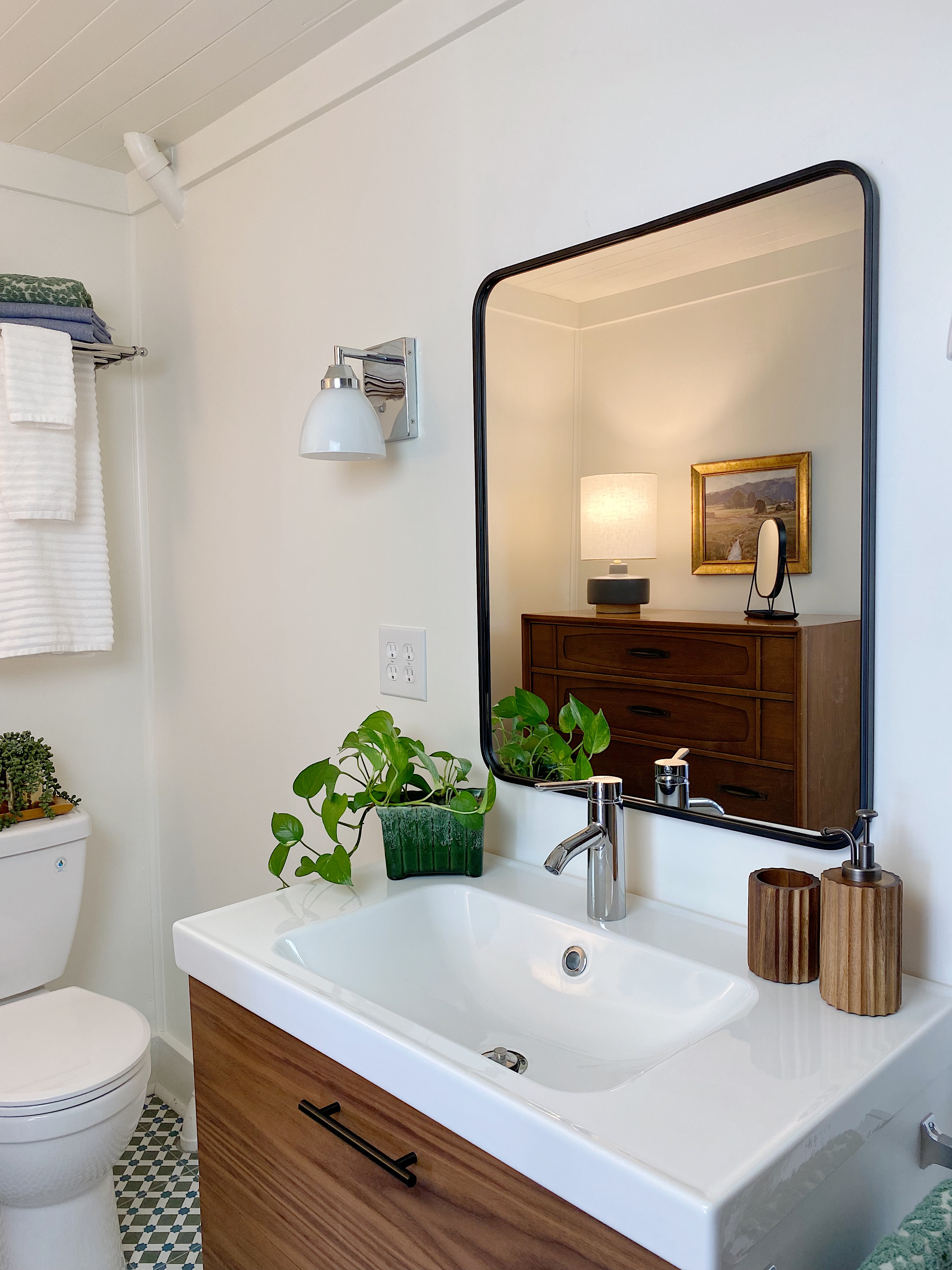 Bathroom with black metal framed mirror, Ikea vanity with walnut drawers