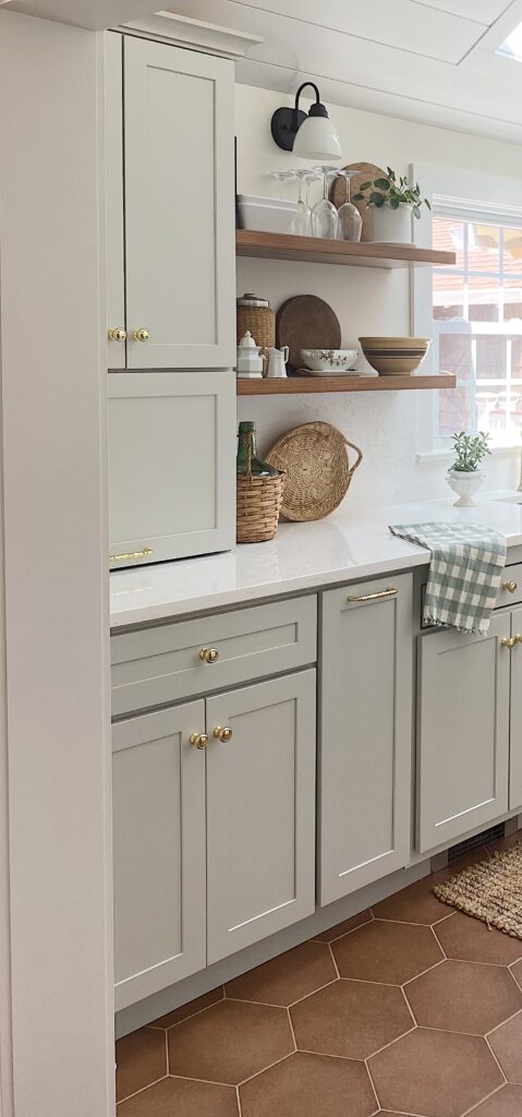 gray kitchen cabinets with quartz counters and wood floating shelves