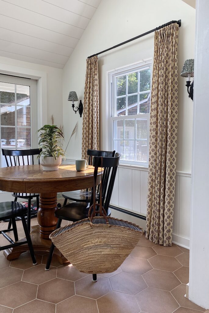 Dining nook with printed curtains and lampshades on wall sconces