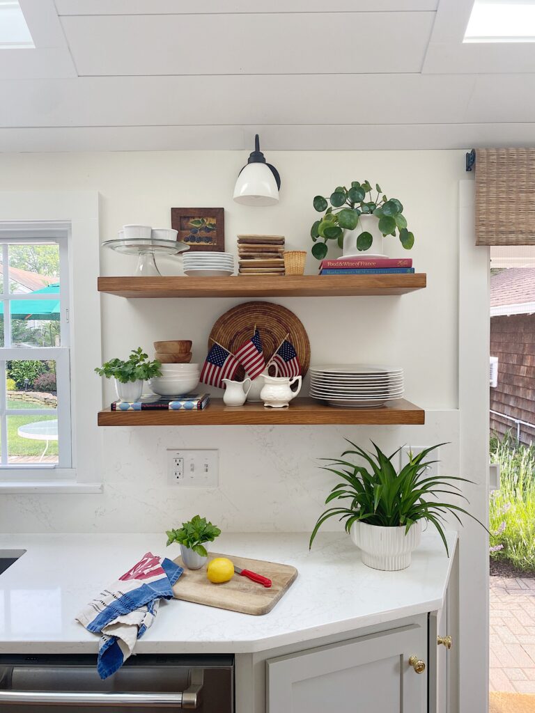 Open oak shelves in kitchen styled with red, white and blue accents
