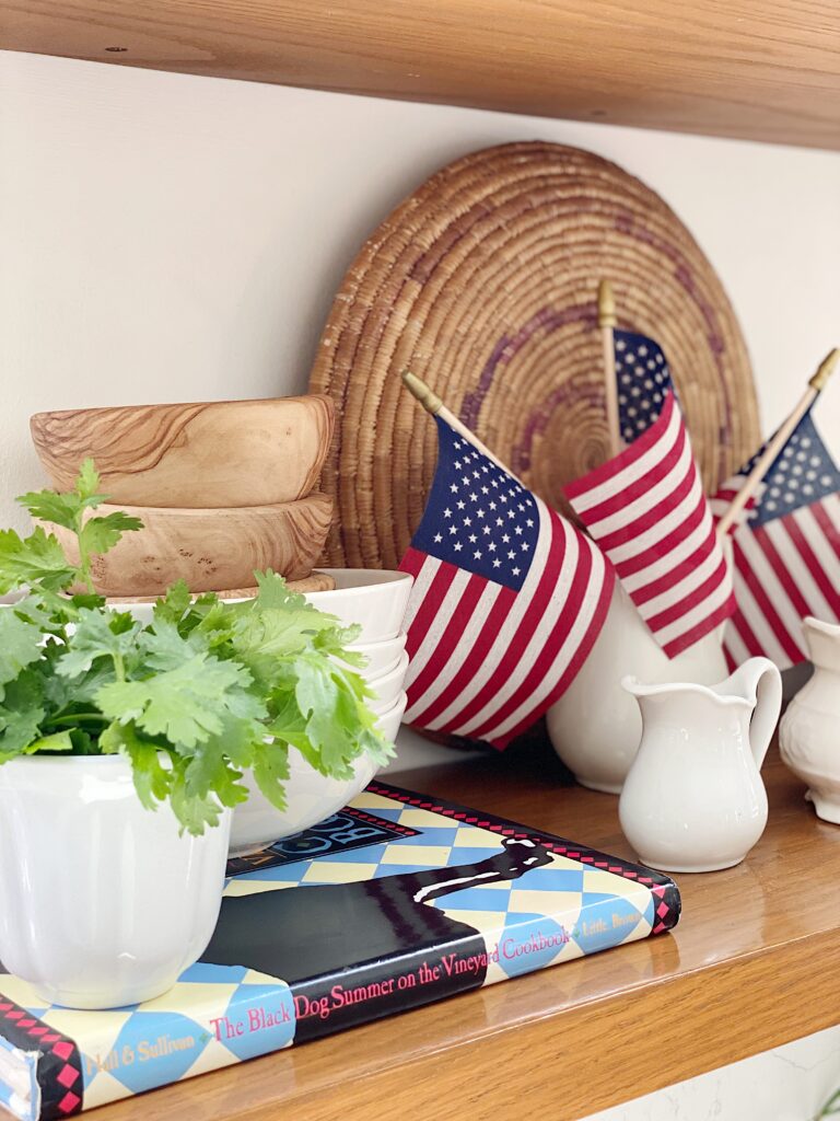 Open kitchen shelves styled for summer with mini American flags