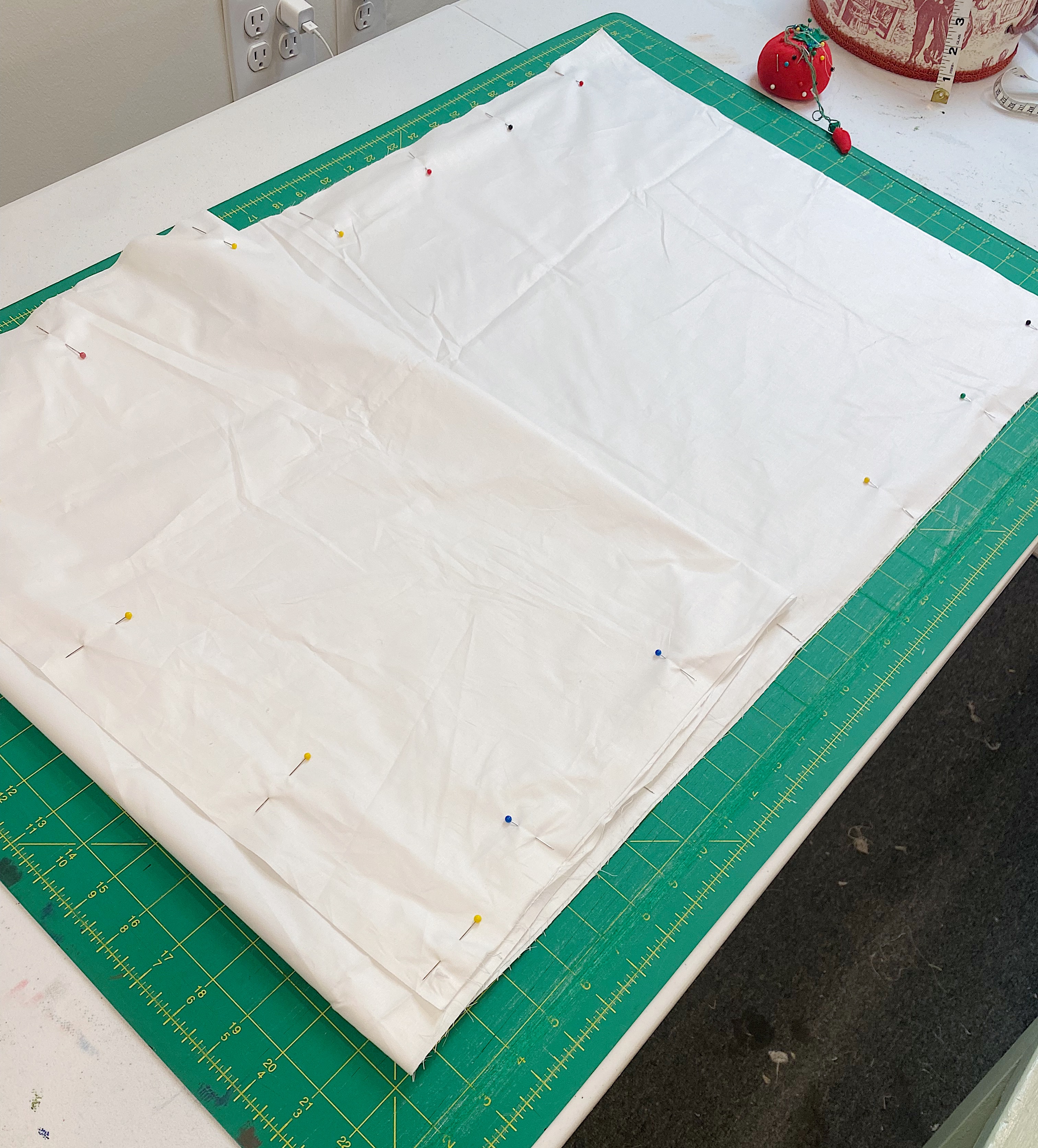 white pillow ticking on cutting mat with pins