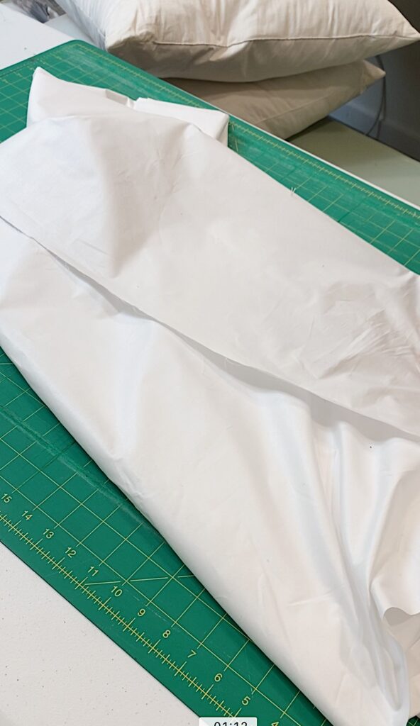 white pillow ticking fabric on cutting mat
